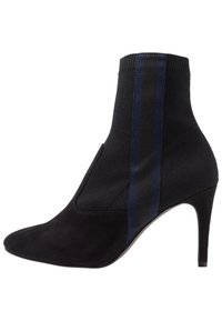 Bota negra hasta el tobillo con punta afilada y tacón de aguja. Fabricada en ante con tejido acanalado y una franja lateral en azul oscuro.