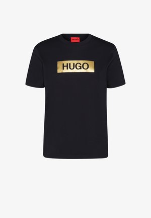 Schwarzes Baumwoll-T-Shirt mit einem goldenen rechteckigen Grafikdesign, auf dem das Wort "HUGO" in fetten schwarzen Buchstaben steht. Kurze Ärmel und Rundhalskragen.