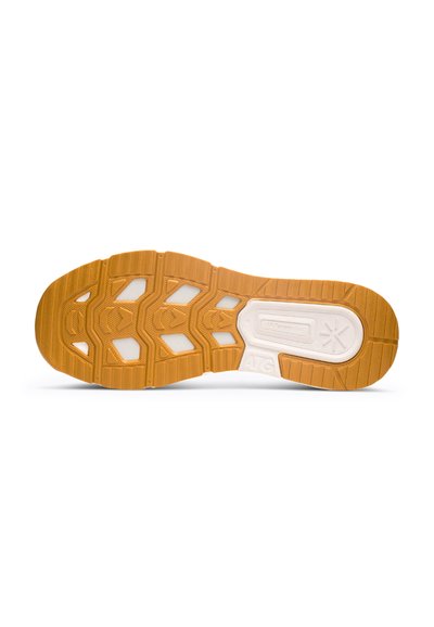 Semelle de chaussure avec une bande de roulement en caoutchouc orange et une section intermédiaire blanche présentant des motifs de grip texturés et les lettres "ATG".