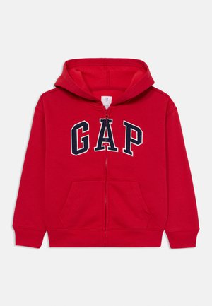 Felpa rossa con zip in cotone, con logo "GAP" blu navy sul davanti, dotata di cappuccio e due tasche frontali. Tessuto morbido, design casual.