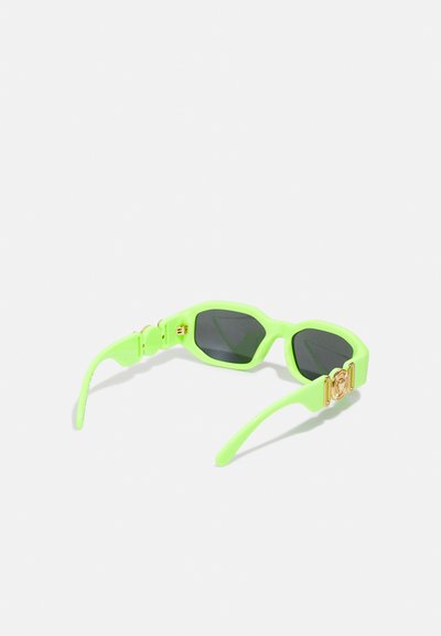 Occhiali da sole verde neon con montatura geometrica, lenti oscurate nere e dettagli in acciaio dorato sulle astine. Finitura liscia e lucida.