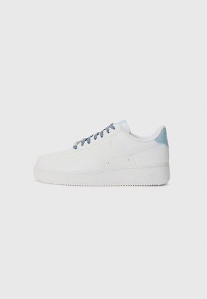White sneaker with a smooth leather finish, featuring a light blue heel accent, grey laces, perforated toe, and textured rubber sole.