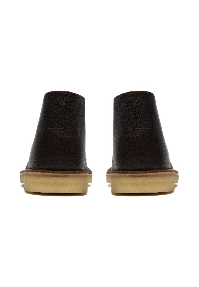 Brown leather ankle boots with a smooth texture, rounded top, and rubber sole. Features contrast stitching and a low-profile heel.