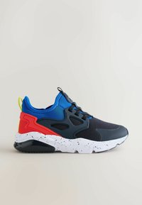 Atletiksneaker med sort mesh-forstykke, blå stofkrave, rød hælstøtte, hvidprikket sål og sort ydersål på ensfarvet baggrund.