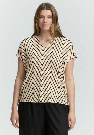 Haut à manches courtes, en V, de couleur beige avec un motif en zigzag marron foncé. Fabriqué en tissu doux avec une coupe décontractée, épaules tombantes et ourlet droit.