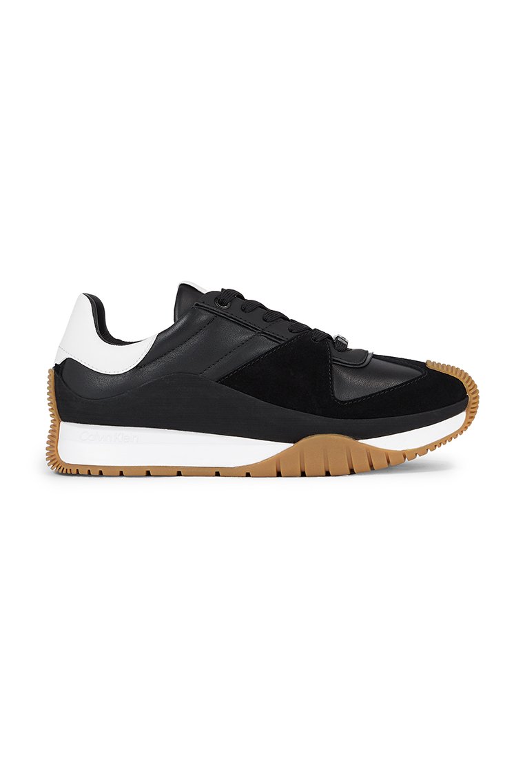 Sneaker nera con pannelli in pelle e suede, dettagli bianchi sul tallone e suola in gomma testurizzata. Presenta un design con lacci.