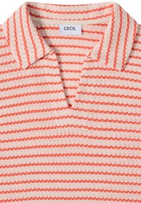 Polo en maille à rayures horizontales orange et blanches, doté d'un col et d'une étiquette de marque "CECIL" à l'intérieur de l'encolure.