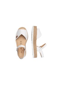 Sandalias de cuero blanco con una suela de plataforma de yute en capas, tirante ajustable en el tobillo y un diseño recortado en la parte superior.