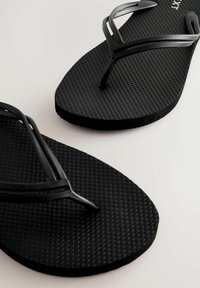 Zwarte teenslippers met een getextureerde rubberen zool en dunne plastic bandjes, met een eenvoudig ontwerp zonder aanvullende patronen of accenten.