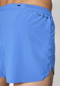 Blaue Sportshorts aus leichtem Material. Mit einem Netzbund, seitlichen Schlitzen und durchlöchertem Design für Atmungsaktivität.