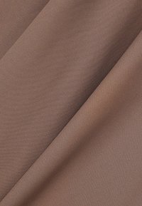 Textil i en medelbrun färg med en jämn, vävd textur, som visar diagonala veck och en subtil glans.