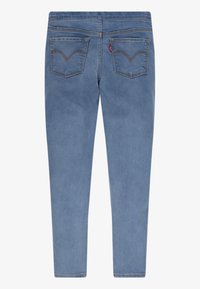 Jeans ajustados de mezclilla azul con un diseño clásico de cinco bolsillos, detalles de costura sutiles y una cinturilla de altura media en la parte posterior.