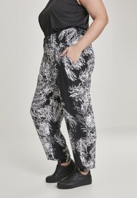 Zwart-witte gestreepte broek van een zachte stof, met een elastische tailleband, zijzakken en een losse pasvorm.