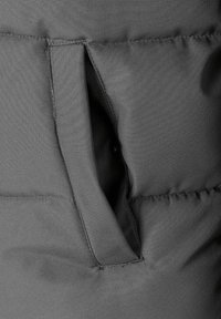 Tela de chaqueta aislante gris con un detalle de bolsillo vertical, presentando una textura suave y costuras limpias a lo largo de los bordes.