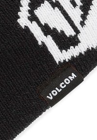Knit beanie in black with white pattern. Features a textured fabric and a small black tag with "VOLCOM" in white lettering.