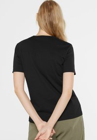 Schwarzes T-Shirt mit kurzen Ärmeln aus Baumwolle, mit Rundhalsausschnitt und lockerer Passform, glatte Textur und ohne sichtbare Muster.