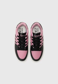 Baskets noires et roses en matériau synthétique lisse, à bouts ronds, avec des lacets noirs et un logo sur les côtés et les semelles intérieures.