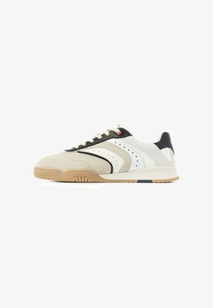 Beige-weißer Sneaker mit niedrigem Schaft, schwarzen und braunen Akzenten, perforierten Seitendetails, weißen Schnürsenkeln und einer Kautschuksohle.