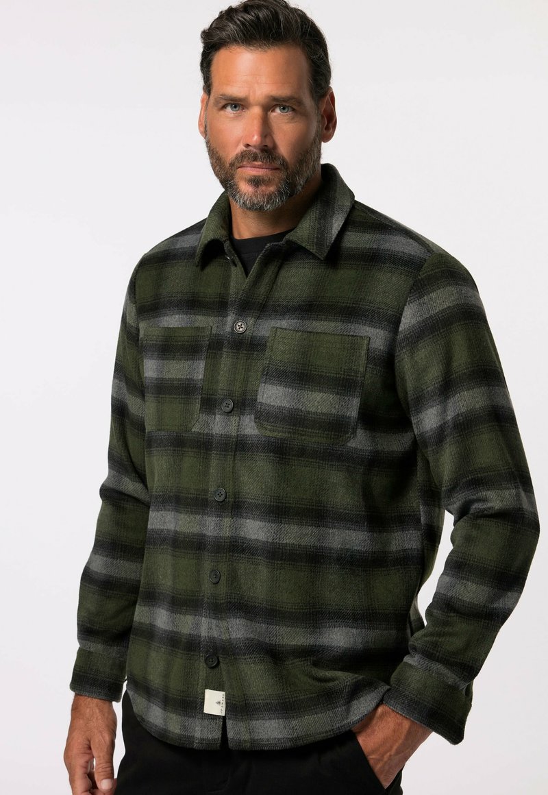 Camisa de franela a cuadros en verde y gris, con cierre de botones en la parte delantera, mangas largas y un bolsillo en el pecho. Textura suave; diseño de patrón cuadrado.