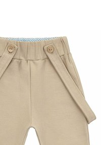 Beżowe spodnie z elastycznym pasem, wyposażone w dwa drewniane guziki i boczne paski. Podszewka w jasnoniebieski w kratkę.