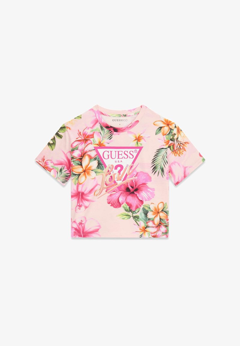 Crop top court à manches courtes rose clair avec imprimé floral tropical et logo "GUESS U.S.A." dans un triangle rose au centre devant.