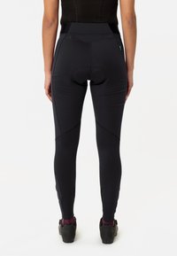 Juodos legging'ų kelnės su aukštu liemeniu, prigludusiu siluetu ir kontrastingomis tekstūrinėmis detalėmis šonuose, su paminkštinta dviračio sėdynės įdėklu.