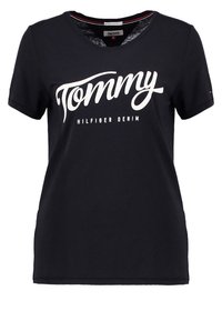 Camiseta de algodón negra de manga corta, con el texto grande en blanco "Tommy" y "Hilfiger Denim" debajo. Diseño clásico de cuello redondo.