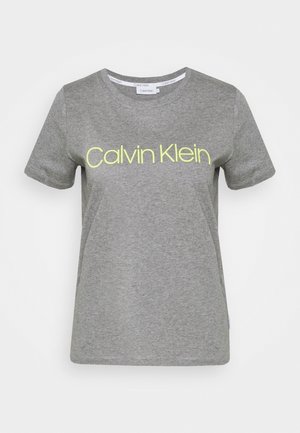 Szara bawełniana koszulka z krótkimi rękawami, okrągłym dekoltem i neonowożółtym logo "Calvin Klein" na piersi. Gładka faktura, luźny krój.