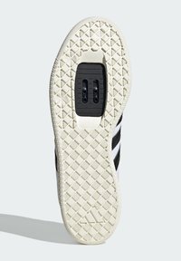 Czarno-biała sneakersy z teksturowaną gumową podeszwą z wzorem w formie diamentów, posiadające centralny obszar mocowania czarnego korka.