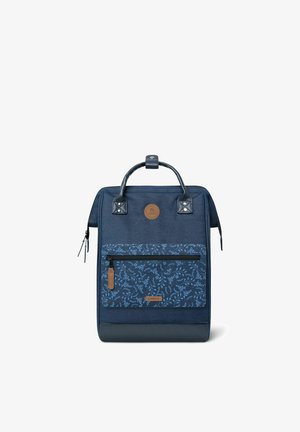 Sac à dos rectangulaire bleu foncé avec une poche avant zippée fleurie, tirette de fermeture éclair en cuir fauve et poignées noires avec fermeture pression.