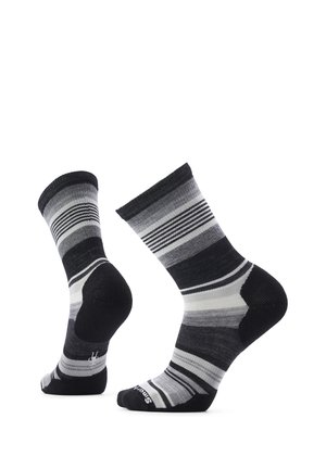 Par de calcetines a rayas negras, blancas y grises hasta la mitad de la pantorrilla, mostrados desde ángulos lateral y trasero sobre fondo blanco.
