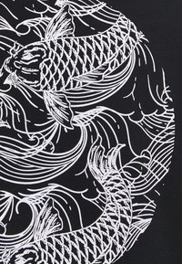 Black fabric with white koi fish design featuring swirling waves, scales, and fins, creating a dynamic, patterned visual effect.