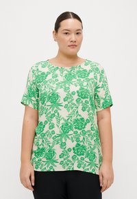 Kortärmad blus i lätt tyg, med ett grönt blommönster på en ljus bakgrund, rundad halsringning och avslappnad passform.