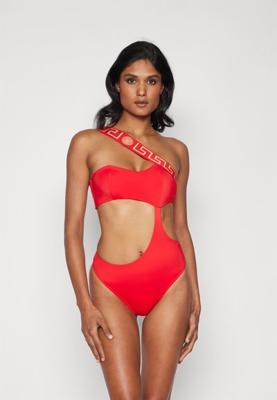 Maillot de bain rouge une pièce avec un design découpé, présentant une large sangle à motifs sur une épaule et une texture de tissu lisse.