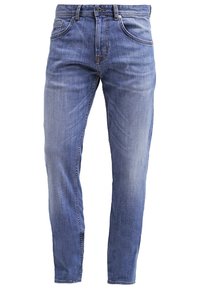 Jean en denim bleu clair avec une coupe slim, comportant cinq poches, des passants de ceinture et une légère décoloration, mettant en valeur la texture et les détails de couture.