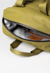 Borsa verde oliva con una texture liscia, dotata di una zip superiore, fodera a scacchi grigia e nera e un'etichetta in cuoio all'interno.