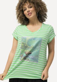 Camiseta de rayas verde y blanca con escote en V, que presenta un gráfico de tortuga y el texto "FELIZ VERANO" en una impresión cuadrada. Mangas cortas, corte casual.