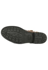Zapato de cuero marrón con suela de goma negra texturizada, que presenta un diseño de grabado para mejor agarre y un diseño moldeado para comodidad y soporte.