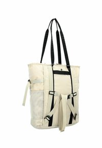 Borsa a spalla in tela beige con manici neri, chiusura con zip, tasca laterale in rete e spallacci regolabili per opzioni di trasporto versatili.