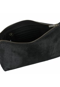 Clutch bag in finto pelo nero con zip dorata. L'interno presenta una tasca con zip e diversi scomparti per carte con una consistenza liscia.
