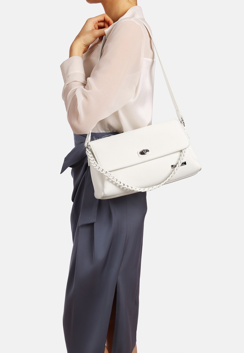 Borsa a tracolla in pelle bianca con texture, chiusura a patta e dettagli in metallo argentato, posizionata su uno sfondo neutro.
