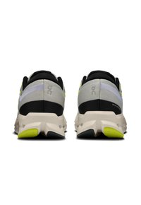 Gray running shoes with black accents and neon yellow details. Textured fabric upper, contoured sole, and prominent heel cushioning.