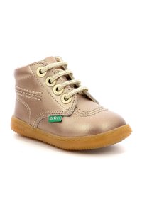 Bottine en cuir doré avec un bout rond, surface texturée, lacets beige et étiquette de logo verte. La semelle en caoutchouc offre bonne adhérence et durabilité.