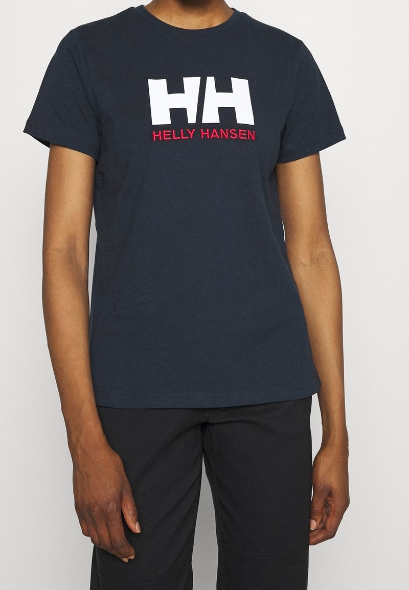 Námořnická modrá bavlněná tričko s bílým logem "HH" a červeným textem "HELLY HANSEN". Krátké rukávy a standardní kulatý výstřih.