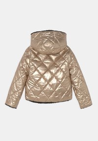 Cropperet pufferjakke i skinnende metallic guld med diamantquiltning, der har hætte og sort faux fur-kant langs kanten og manchetterne.
