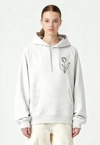 Felpa con cappuccio grigia chiara con coulisse, tasca a marsupio e un disegno a linea nera di un tulipano sul petto. Presenta polsini a coste.