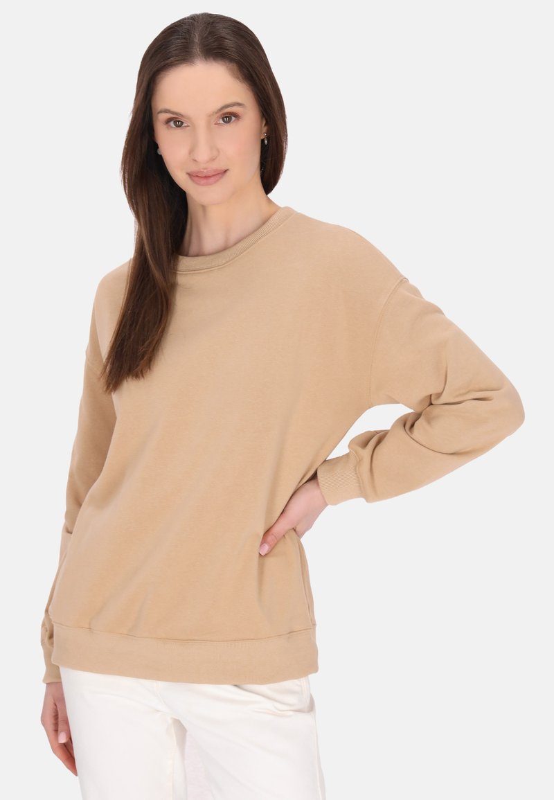 Beige pulóver kerek nyakkal, hosszú ujjakkal és laza fazonnal. A puha anyag sima tapintású, bordázott mandzsettákkal.