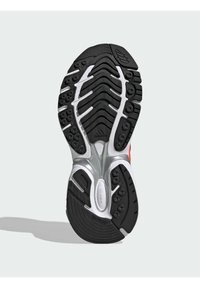 Talpa de pantof de alergare negru cu accente albe și argintii, având un model de cauciuc texturat, tipare circulare de prindere și logo-ul 'adidas'.