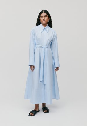 Lichtblauwe, lange mouw jurk met een verstelbare taille, geplisseerde rok en knoopsluiting bij de kraag. Gladde stof met brede manchet en naden.