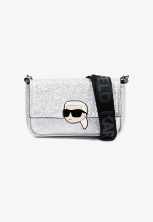 Zilverkleurige glitter crossbodytas met zwarte band, voorzien van de opvallende tekst "Karl Lagerfeld" en een cartoongezicht met zonnebril en wit haar op de voorflap.